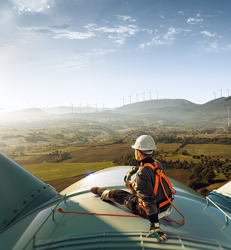 A man in white helmet sitting on top of an airplane.