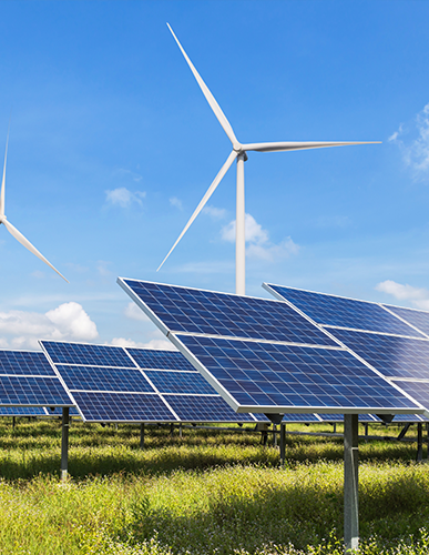 A field with many solar panels and wind mills.