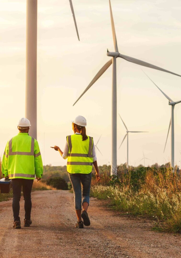 Wind farm engineers walking, sunset.