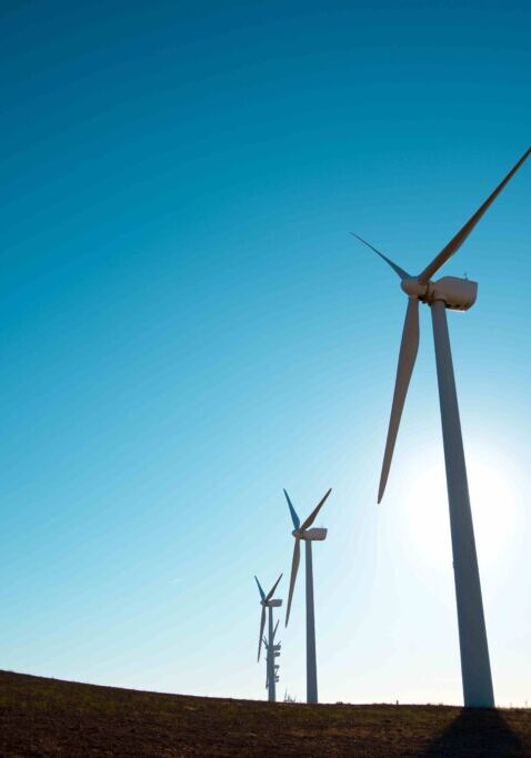 Wind turbines in a clear blue sky.